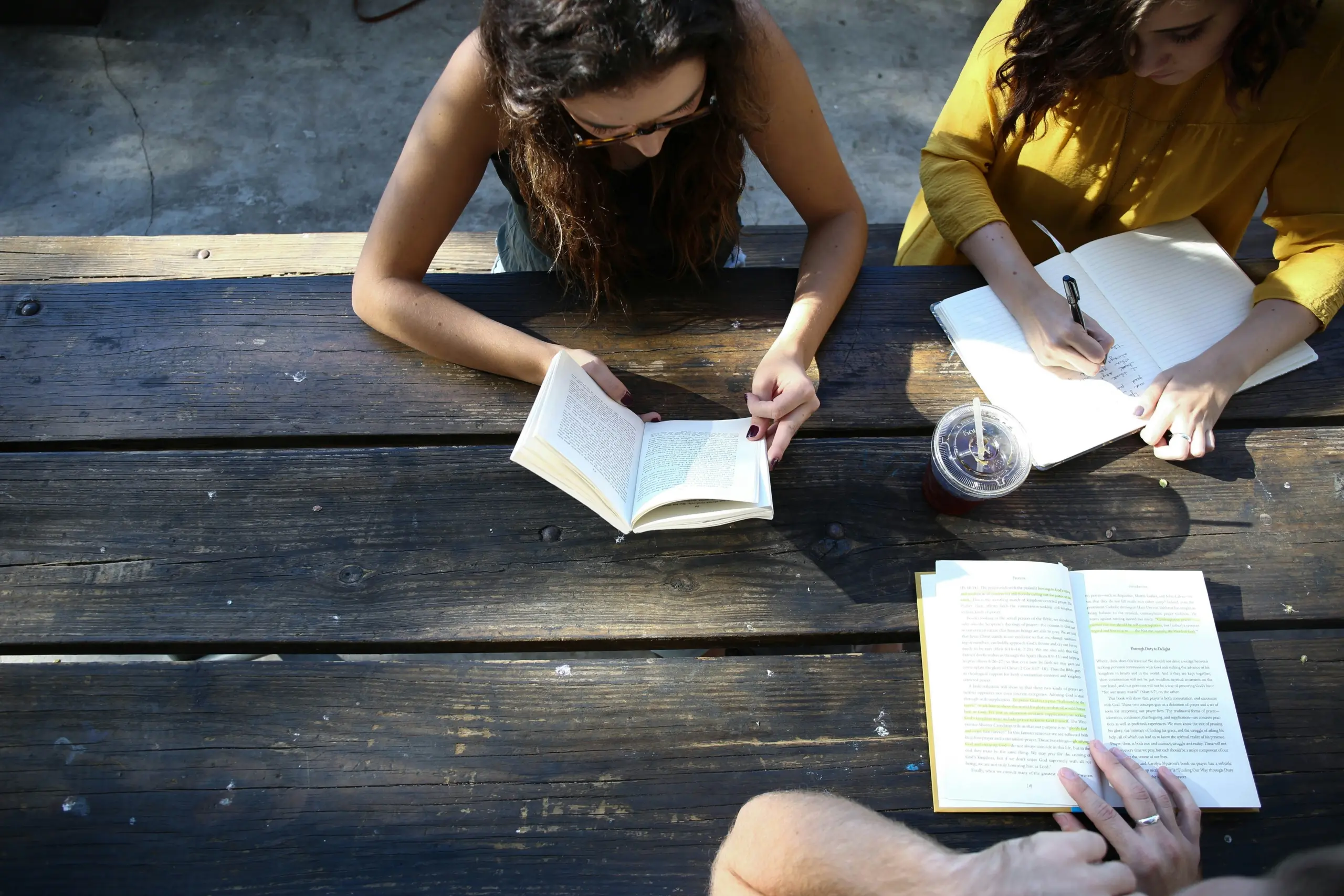 group of people working together on a desk with notebooks